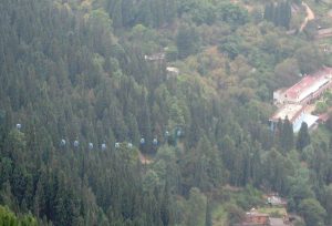 Description: Blue cablecar pods climb up from the station in Gejiu town in Honghe prefecture in southeastern Yunnan province in China to the viewpoint of the town and its lake way above 