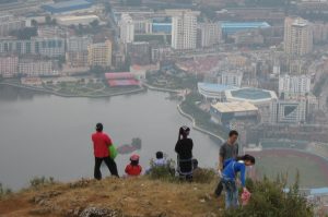 People who have reached the viewpoint of Gejiu town and its lake in Honghe prefecture in southeastern Yunnan province in China enjoying the view